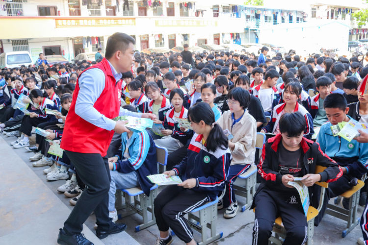 禁毒志愿者向学生发放禁毒和反邪教知识的宣传单.JPG